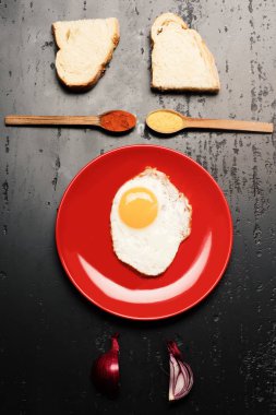 Baharatlar, ekmek dilimleri kaşıklarla yakınındaki kızarmış yumurta ile çanak