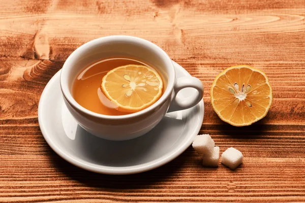 Xícara de chá verde com fatia de fruta laranja. — Fotografia de Stock