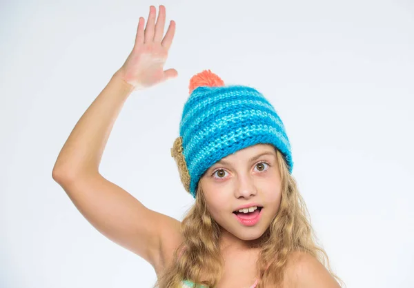無料ニット パターン。ポンポン ニット帽子。幸せそうな顔の白い背景の長い髪少女。子供は、暖かく柔らかいニットの青い帽子を着用します。編みとかぎ針編みの違い。秋冬シーズン アクセサリー — ストック写真