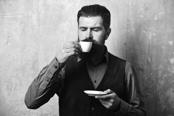 Facet pije herbatę z filiżanki herbaty. Barman z zadowolonych twarzy — Zdjęcie stockowe