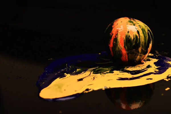 Orange or grapefruit covered with paints, copy space