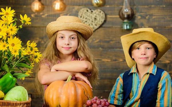 Elementary school fall festival idea. Kids girl boy wear hat celebrate harvest festival rustic style. Celebrate harvest festival. Children near vegetables wooden background. School festival holiday