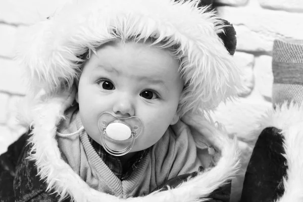 흰색 벽돌 벽 backgroun에 새 해 모자에 더미와 배에 노란 스웨터에서 귀여운 호기심 얼굴 작은 아기 — 스톡 사진