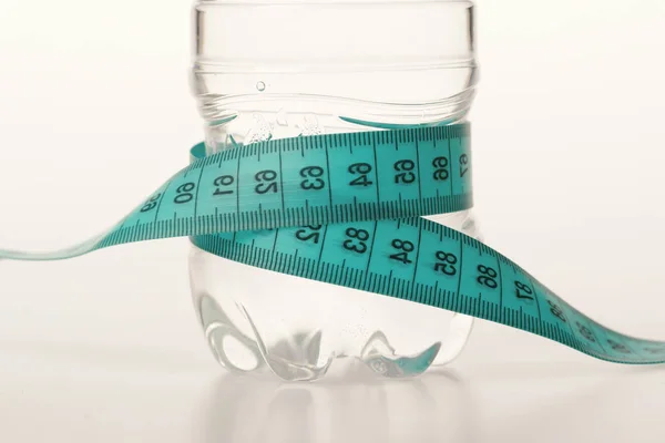 Concepto de dieta y régimen deportivo. Botella de agua atada con cinta — Foto de Stock