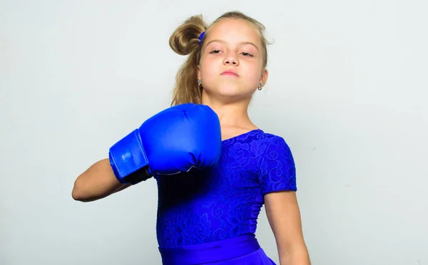 She feels strong and independent girl. Sport upbringing for girls. Feminist movement. Strong child concept. Kid strong and healthy. Girl child strong with boxing gloves posing on grey background — Stock Photo, Image
