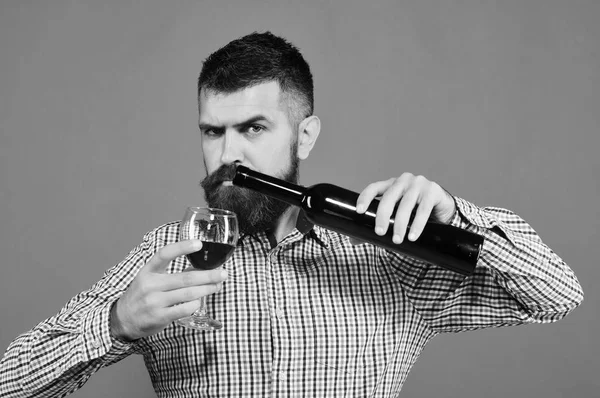 Винороб з суворим обличчям тримає келих і пляшку вина — стокове фото