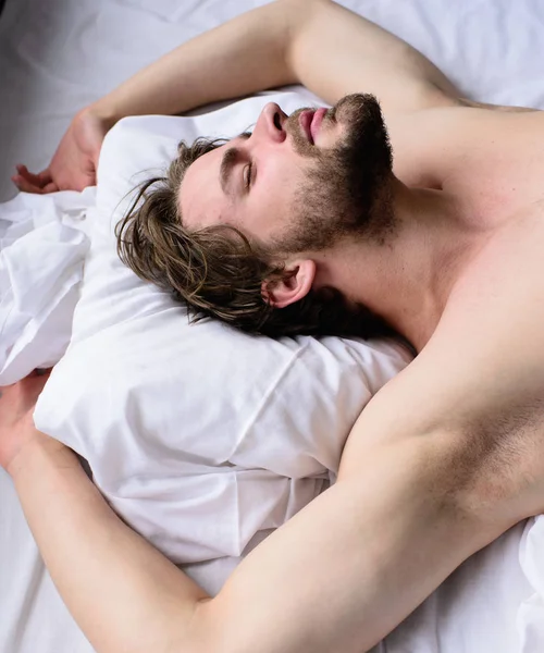 Ο άνθρωπος nap ύπνου γυμνό κορμό αξύριστος όμορφος άντρας στο κρεβάτι. Ύπνου υπνηλία αξύριστος πρόσωπο γενειοφόρος άνδρας έχει υπόλοιπο. Ευχάριστο όνειρο έννοια. Σέξι macho άντρα γεννούν άσπρα σεντόνια. Αφήστε το σώμα σας να αισθάνονται άνετα — Φωτογραφία Αρχείου