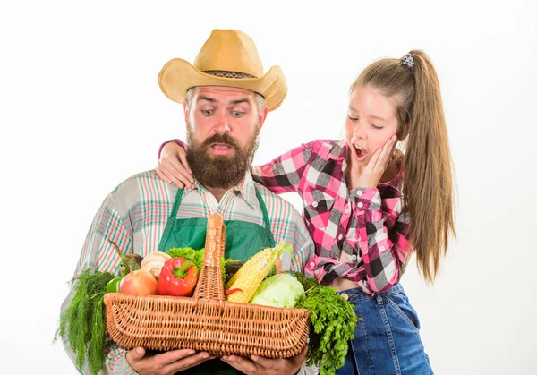 Family farm organic vegetables. Father farmer or gardener with daughter hold basket harvest vegetables. Man bearded rustic farmer with kid. Farmers family homegrown harvest. Gardening and harvesting.