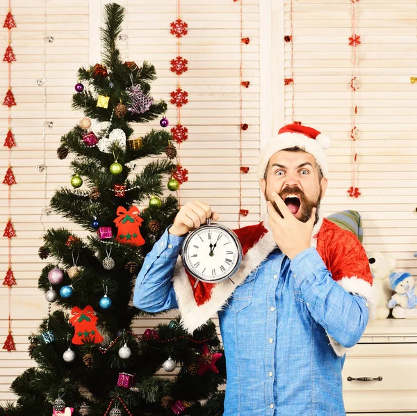 Санта-Клаус с диким лицом у елки на фоне — стоковое фото