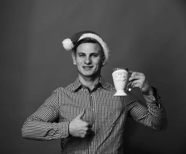 Santa con copa sobre fondo rojo. El hombre tiene taza de vacaciones — Foto de Stock