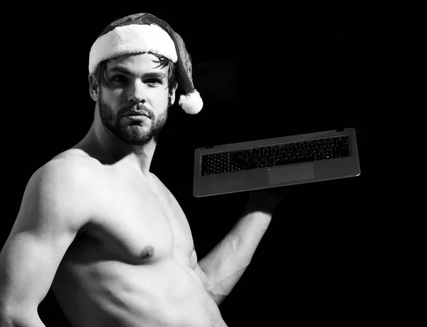 santa muscular man with laptop in hat