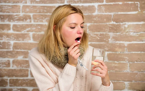 Neem medicijnen te verminderen van koorts. Hoofdpijn en koorts remedies. Vrouw verwarde haren sjaal houd glas water en tabletten blister. Meisje voelt zich ziek koorts lijden en neem geneeskunde. Pillen voor het breken van koorts — Stockfoto