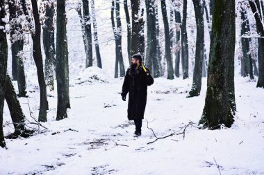 Kürk ceket omuz balta ile ormandaki adam