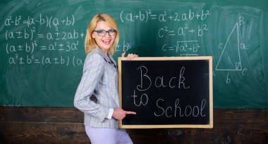 Öğretmen kadın tutun blackboard yazıt geri okula. Yine okul vakti geldi. Okul öğretmeni mutlu hoş geldiniz öğrenciler. Öğretim yılı büyük başlangıcı. En iyi yolu geri schoo öğrencilere Merhaba