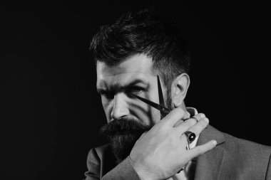 Sakallı çelik makas tutar. İşadamı kötü yüzü ile