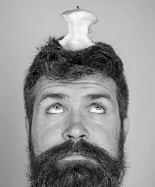 Adam yakışıklı hipster uzun sakal neredeyse kafasına elma güdük hedef olarak yem. Canlı hedef kavramı. Kilo kaybı gol. Hipster sürpriz yüz baş mavi arka plan üzerinde elma güdük hedefle yakın