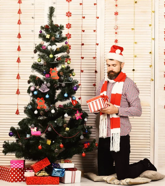 Guy stands by Christmas tree and boxes — Stock Photo, Image