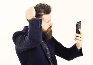Selfie, apps, sosyal ağ kavramı. Sakallı adam smartphone vasıl görünüyor. Hippi uzun sakallı ve ciddi bir yüz ile. Adam cep telefonu önünde saç düzeltiyor. Moda ve stil, yeni teknolojiler