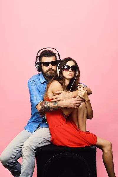 Man with beard wears headphones and sunglasses.