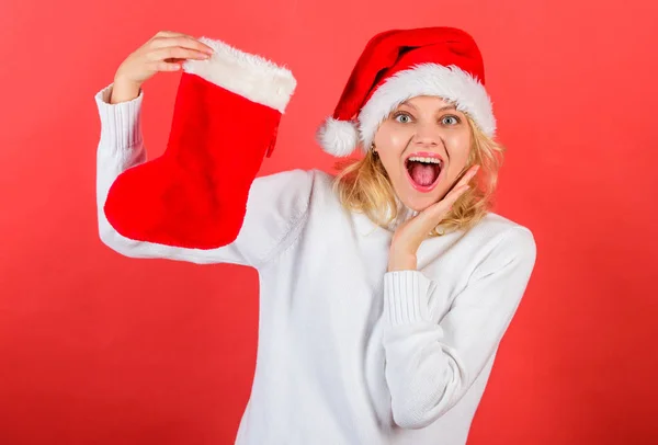 检查圣诞袜的内容 圣诞老人帽子的妇女持有圣诞节礼物红色背景 女孩欢快的脸得到礼物在圣诞袜 圣诞放养概念 传统冬季假期 — 图库照片
