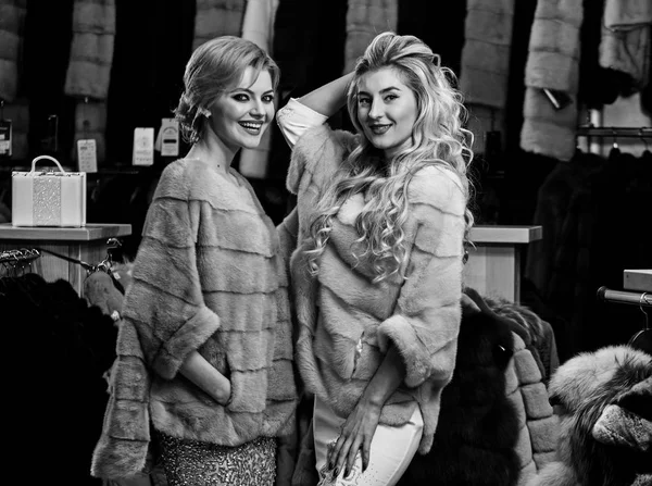 Богатая концепция моды. Девушки с улыбающимися лицами носят пушистые пальто — стоковое фото