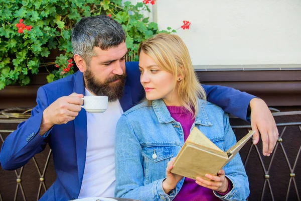 Amor e namoriscar. Interesses comuns. Casal apaixonado sentar terraço café. Homem com barba e mulher loira abraçar em encontro romântico. Conceito de romance. Casal flertando romântico data ler livro. Data romântica — Fotografia de Stock