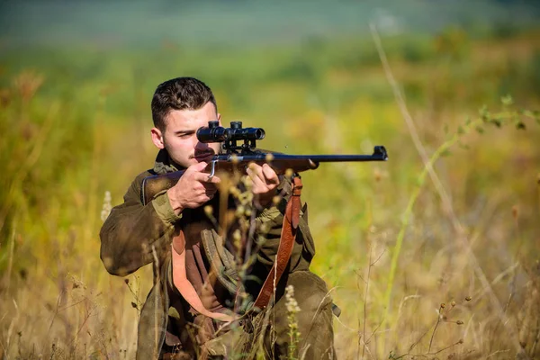 Guy hunting nature environment. Hunting weapon gun or rifle. Hunting target. Masculine hobby activity. Experience and practice lends success hunting. Man hunter aiming rifle nature background