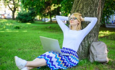 Wi fi ağ bağlantısı ücretsiz erişim. Kadın dizüstü işleri açık, park arka plan ile. Ücretsiz wi fi avantajları alarak. Kız oturup ot yalın ağaç gövdesi ile defter. Bayan freelancer Park'ta çalışma