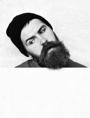 Stüdyo duvarında poz veren sakallı adam.