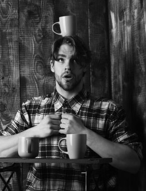 Ahşap arka planda bardakları tutan yakışıklı adam.