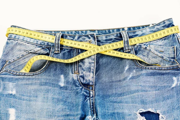 Fabrication de vêtements : ruban de mesure jaune utilisé comme ceinture sur un jean — Photo