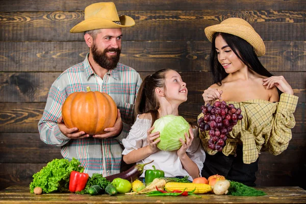 Ρουστίκ στυλ οικογένεια αγορά αγροτών με πτώση συγκομιδή. Γονείς και κόρη Γιορτάστε διακοπών συγκομιδή κολοκύθα λαχανικά φρούτα. Έννοια του φεστιβάλ συγκομιδή. Τους αγρότες της οικογένειας με φόντο ξύλινη συγκομιδή — Φωτογραφία Αρχείου