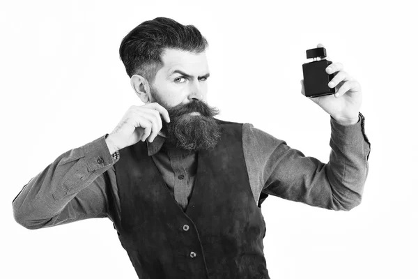 Homme barbu tenant parfum avec un visage sérieux — Photo