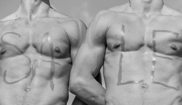 Baús de atletas musculosos sexy, torso nu e céu no fundo. Venda de inscrição em peitos musculares sexy. Torsos musculares de desportistas fortes com venda de palavras escrito em. Conceito de venda — Fotografia de Stock