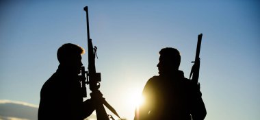 Avcı arkadaş eğlence keyfini çıkarın. Avcılık ortağı ile daha büyük ölçü Emanet eğlenceli ve ödüllendirici sağlar. Avcılar arkadaşlar gamekeepers silahlı gökyüzü arka plan siluet. Avcı tüfekler doğa ortam