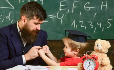 Baba sakallı, evlat, öğretmen öğretir küçük çocuk, çocuk onu yenerek iken. Neşeli boks baba yenerek, evlat. Öğretmen ve öğrenci kolej, kara tahta arka plan içinde. Oynak çocuk kavramı