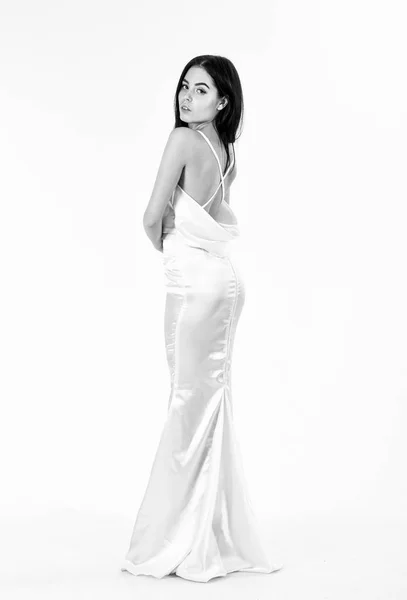 Νύφη, χαριτωμένη κοπέλα στο φόρεμα. Μόδα μοντέλο δείχνουν ακριβά μοντέρνες βραδινό φόρεμα ή το γαμήλιο φόρεμα. Γάμος έννοια της μόδας. Γυναίκα στο κομψό λευκό φόρεμα με γυμνό πίσω, λευκό φόντο — Φωτογραφία Αρχείου