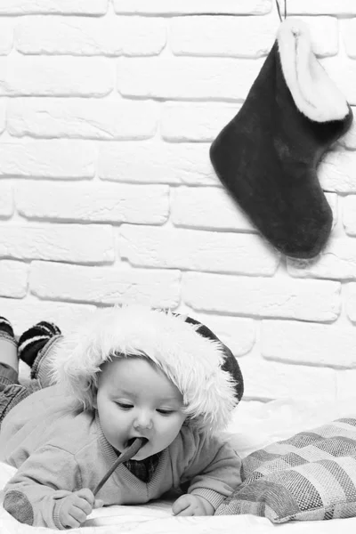 Mały chłopczyk z adorable curious oblicze w żółty sweterek na brzuch w hodowli kapelusz i Boże Narodzenie lub Boże Narodzenie nowy rok lub rozruchu na tle ściany Cegła biała — Zdjęcie stockowe
