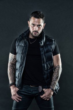 Erkeklik ve moda kavramı. Dövme acımasız özniteliği. Adam kendine güvenen tıraşsız acımasız görünüm silah dövme. Dövme büyük yolu erkeklik ve erkeklik ifade eder. Sakallı adam dövmeler ile poz