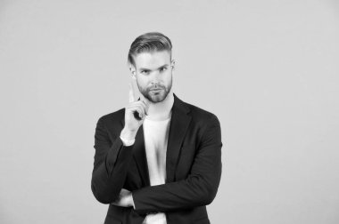 Adam çekici gösterir jest uyarı sakallı. Dikkat kavramı. Sakal tıraşsız adam adam yakışıklı bakımlı formal giyim görünüyor. İşadamı sıkı sakin uyarı yüz gri arka plan sakallı