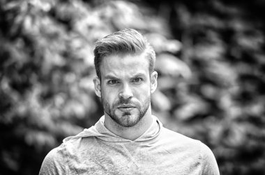 Yakışıklı tarzı. Adam görünümü hakkında çekici umurunda sakallı. Adam defocused ciddi bir yüz, yeşil doğa arka plan, kıl. Metroseksüel kavramı. Adam sakal tıraşsız adam yakışıklı ve serin görünüyor