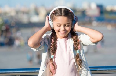 Küçük kız müzik dinleme keyfini en sevdiğim şarkı. Kız kulaklık kentsel arka plan ile. Müzik olumlu etkisi. Müzik modern kulaklık zevk kız çocuk. Çocukluk ve gençlik müzik tadı
