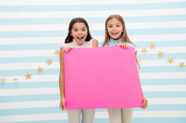 Удивительные новости. Девушка держит плакат с объявлением. Девочки держат бумажный баннер для объявления. Дети счастливы с чистым бумажным объявлением копировать пространство. Детское объявление — стоковое фото