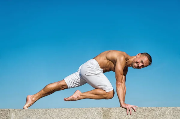 Hombre practicando yoga fondo cielo azul. Llegó a la paz mental. Concepto de meditación y yoga. El yoga ayuda a encontrar el equilibrio. Practica asana al aire libre. La práctica de yoga ayuda a encontrar armonía y equilibrio — Foto de Stock