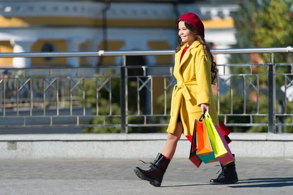 Child adorable stylish hold bunch shopping bags. Girl cute little lady dressed french style coat and beret carry shopping bags. Autumn shopping concept. Little child shopping fall sale season — Stock Photo, Image