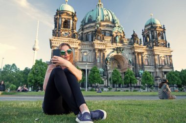 Berlin Katedrali 'nin önünde oturmuş selfie çekiyordu.