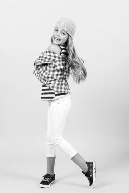 Uzun sarı saçlarıyla gülümseyen bir çocuk.