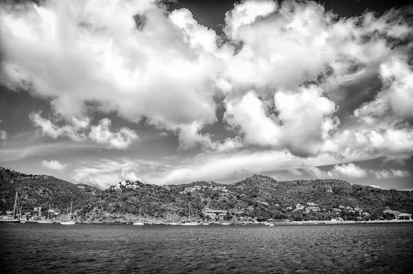 Destino de vacaciones mientras viaja y anhela. Orilla de la montaña en el mar azul en el cielo nublado en gustavia, st.barts. Vacaciones de verano en la isla tropical. Naturaleza y medio ambiente silvestres, ecología —  Fotos de Stock