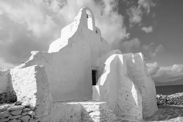 Iglesia de Panagia Paraportiani en Mykonos, Grecia. Edificio capilla con pequeño campanario. Arquitectura de iglesia blanca sobre cielo azul nublado. Concepto de religión y culto. Vacaciones en la isla mediterránea — Foto de Stock