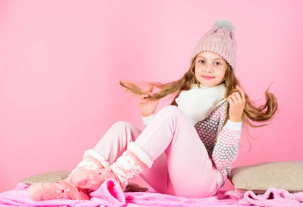 Kid lachende fotomodel. Jongen meisje draag leuke gebreide muts van modieuze en comfortabele gezellige kleding. Winter mode concept. Meisje lang haar ontspannen roze achtergrond. Winter mode voor kinderen — Stockfoto